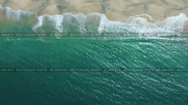 The ocean is calm and the sky is blue. The beach is empty and the waves are small. Стоковое видео, видеограф Дмитрий Брусков / Фотобанк Лори