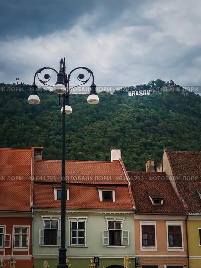 The old town of Brasov with colorful vintage buildings in traditional saxon style with the view to the sign on top of the hill. Popular tourist location in Romania. Стоковое фото, агентство Ingram Publishing / Фотобанк Лори