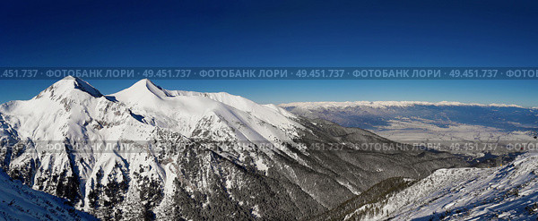 The panoramic mountain view with rocks, ice and fir forest in Pirin mountains, Bansko, Bulgaria. Calm clear blue sky perfect for active life, climbing, hiking and trekking. Стоковое фото, агентство Ingram Publishing / Фотобанк Лори