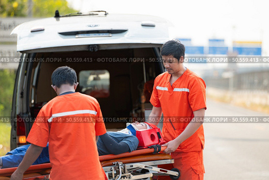The paramedic  is assisting an injured man in an emergency situation on the road. Стоковое фото, агентство Ingram Publishing / Фотобанк Лори
