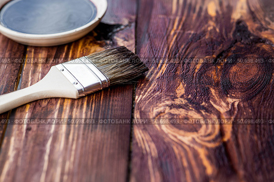 The procedure for protecting and coating wooden boards. The texture of wood treated with stain. Close-up of stain and brush. Стоковое фото, фотограф Photojuli / Фотобанк Лори