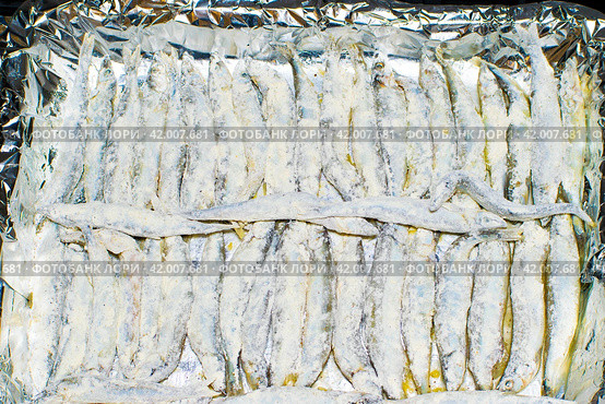 The process of cooking capelin in the oven. decomposed fish on a baking sheet. selective focus. Стоковое фото, фотограф Антон Вахрушев / Фотобанк Лори