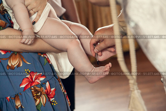 The sacrament of baptism in the Orthodox Church. The priest anoints the child's feet with oil. Стоковое фото, фотограф Екатерина Красникова / Фотобанк Лори