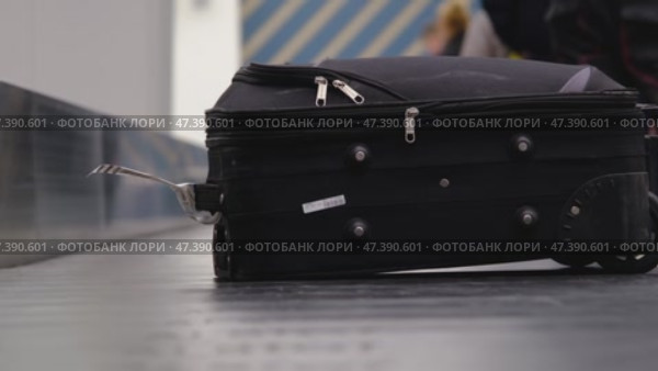The suitcase goes along the conveyor belt at the airport in the baggage receiving area, tourists take their suitcases. Стоковое видео, видеограф Ольга Симонова / Фотобанк Лори