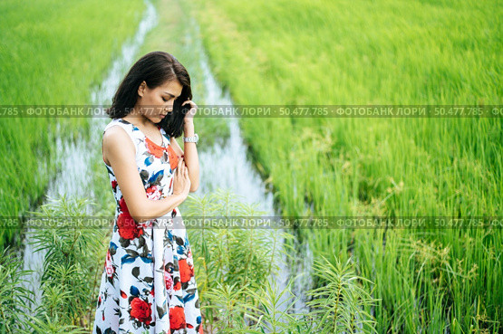 The woman stood strained and her hand touched the face in the meadow. Стоковое фото, агентство Ingram Publishing / Фотобанк Лори