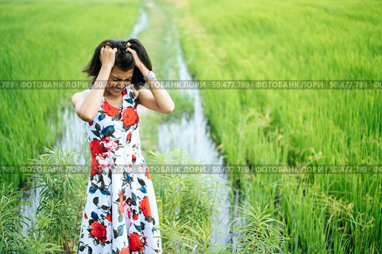 The woman stood tense and the hand held her hair in the meadow. Стоковое фото, агентство Ingram Publishing / Фотобанк Лори