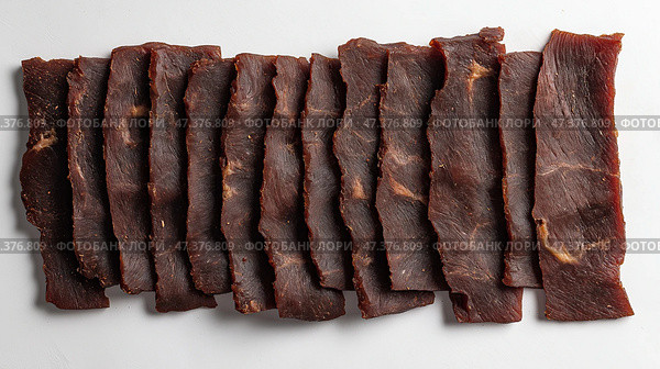 Thin slices of jerky, showing a rich, dark texture with visible marbling. Тонкие ломтики вяленого мяса с насыщенной, темной текстурой и видимой мраморностью. Стоковое AI-изображение, AI-художник Katsiaryna Repich / Фотобанк Лори
