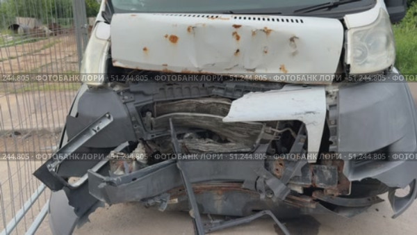 This minibus was significantly damaged as a result of a serious head-on collision. A seriously damaged grey minibus, which shows significant collision marks in the front and extensive rust marks. Стоковое видео, видеограф worker / Фотобанк Лори