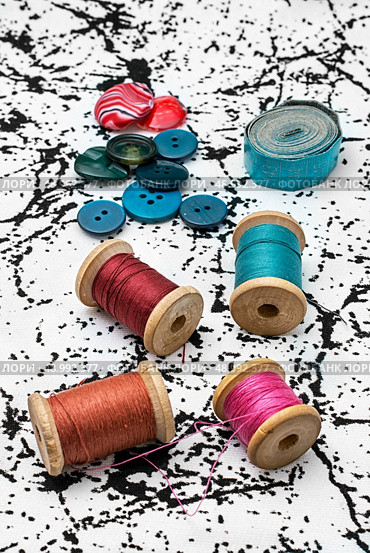thread and buttons against the background of their white textile with black stripes. working tool dressmaker. Стоковое фото, агентство Ingram Publishing / Фотобанк Лори