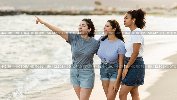 three female friends admiring view beach. Стоковое фото, агентство Ingram Publishing / Фотобанк Лори