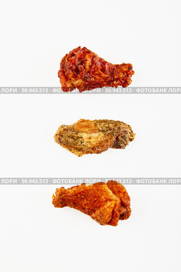 Three fried chicken wings in breading and different sauce on white background. Стоковое фото, фотограф Ирина Буракова / Фотобанк Лори