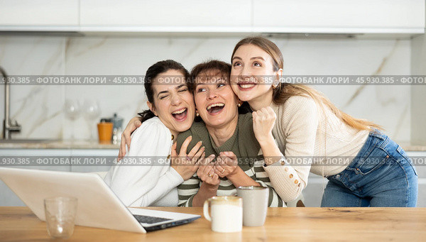 Three happy middle-aged woman expressing joy for winning in the kitchen. Стоковое фото, фотограф Яков Филимонов / Фотобанк Лори