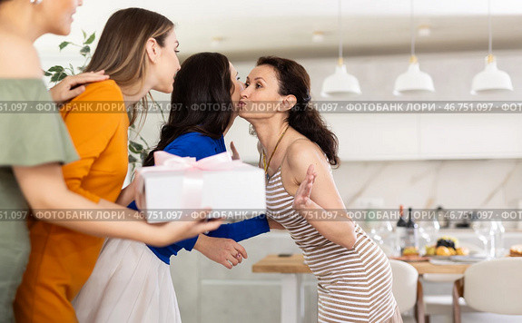 Three women have arrived for birthday celebration and presenting gift to birthday woman. Стоковое фото, фотограф Яков Филимонов / Фотобанк Лори