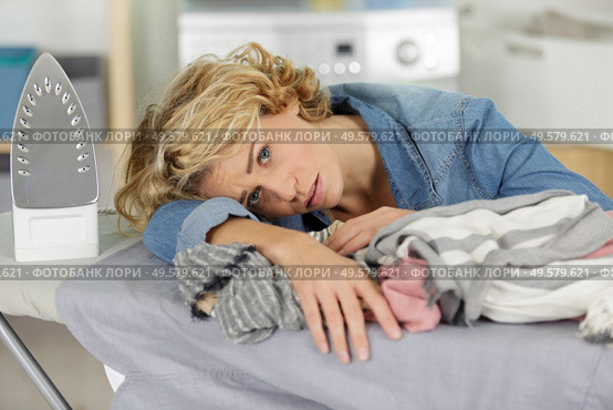 tired woman leaning on her ironing board. Стоковое фото, агентство Ingram Publishing / Фотобанк Лори