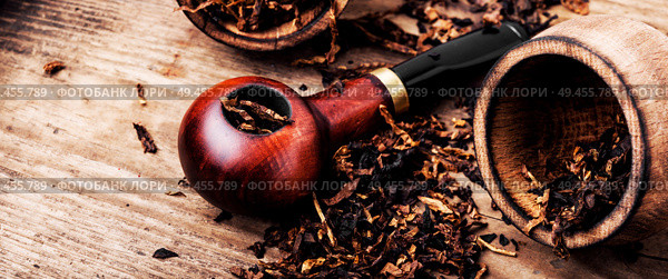 Tobacco pipe or smoking pipe on a wooden table. Smoking pipe and tobacco. Стоковое фото, агентство Ingram Publishing / Фотобанк Лори