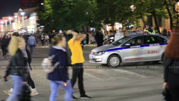 Толпа на ночных улицах города. Полицейский автомобиль с мигалками. Редакционное видео, видеограф Евгений Ткачёв / Фотобанк Лори