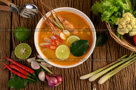 Tom Yum Kung Thai hot spicy soup shrimp with lemon grass,lemon,galangal and chilli on wooden background Thailand Food. Стоковое фото, агентство Ingram Publishing / Фотобанк Лори