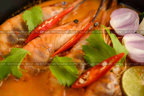 Tom Yum Kung Thai hot spicy soup shrimp with lemon grass,lemon,galangal and chilli on wooden background Thailand Food. Стоковое фото, агентство Ingram Publishing / Фотобанк Лори