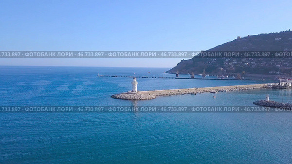 Top view of beautiful seascape with white lighthouse off coast of resort town. Стоковое фото, фотограф David Kashakhi / Фотобанк Лори