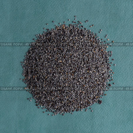 Top view of poppy seeds against blue vinyl background. Стоковое фото, агентство Ingram Publishing / Фотобанк Лори