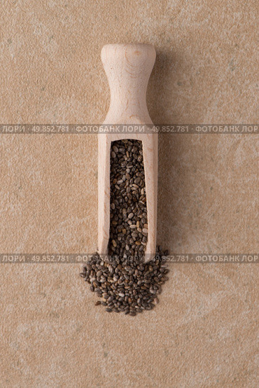 Top view of wooden scoop with chia seeds against beige vinyl background. Стоковое фото, агентство Ingram Publishing / Фотобанк Лори