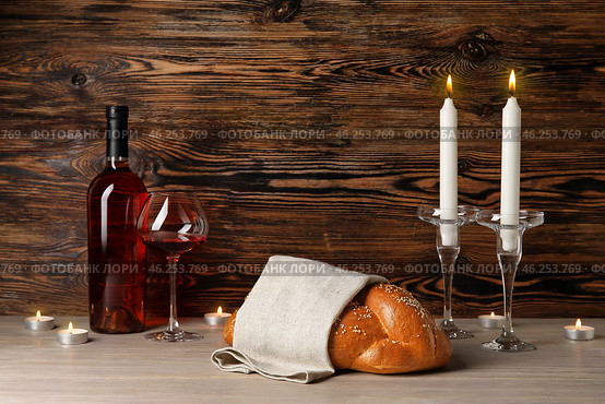 Traditional challah bread with wine and glowing candles on wooden background. Shabbat Shalom. Стоковое фото, фотограф Pixel_shot / Фотобанк Лори