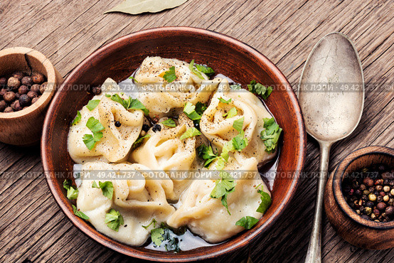 Traditional dish pelmeni.Meat dumplings on wooden rustic background.Russian food. Pelmeni in bowl. Стоковое фото, агентство Ingram Publishing / Фотобанк Лори