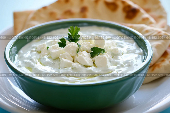 Traditional Greek Tzatziki dip sauce made with cucumber sour cream. Yogurt sauce with dill, lemon juice, olive oil. Served with toasted Za'atar Pita bread. Top view. Tarator, cacik or tartar. Стоковое AI-изображение, AI-художник Марина Демидюк / Фотобанк Лори