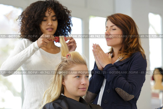 trainee hairdresser practicing using curlers. Стоковое фото, агентство Ingram Publishing / Фотобанк Лори