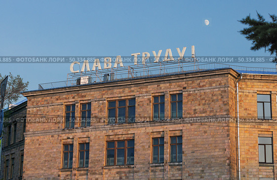 Транспарант "Слава труду!" на крыше завода. Старое кирпичное здание проходной. Санкт-Петербург, Россия. Редакционное фото, фотограф Grigory_Gez / Фотобанк Лори