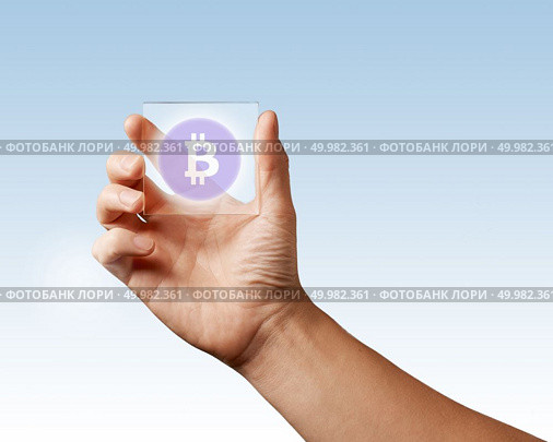 Transparent digital screen is held by a male hand with a bitcoin icon on a blue background. Business, technology and cryptocurrency concept. A man’s hand holds a transparent digital screen with a bitcoin icon ns blue background. Стоковое фото, агентство Ingram Publishing / Фотобанк Лори