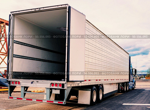 Transport truck trailer sitting in yard with a row of trailers behind it. Стоковое фото, агентство Ingram Publishing / Фотобанк Лори