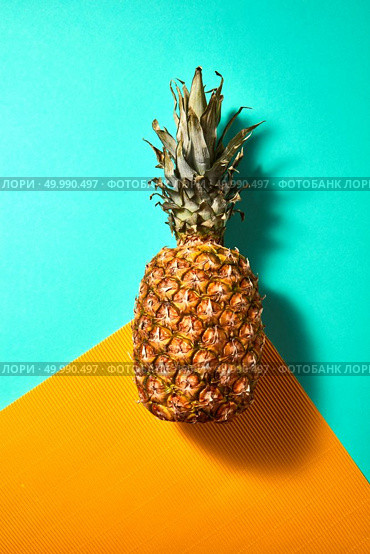 Tropical Pineapple fruit presented on a green orange background top view. Ripe pineapple isolated on an orange green background top view. Стоковое фото, агентство Ingram Publishing / Фотобанк Лори