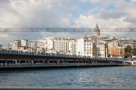 Turkey, Istanbul. A view of the Galata Bridge and the Galata Tower and a beautiful cloudy sky. A view of the Galata Bridge and the Galata Tower. Стоковое фото, агентство Ingram Publishing / Фотобанк Лори