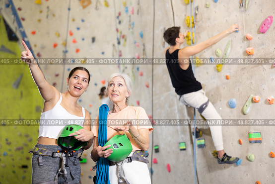 two active female marathon participants are standing in climbing hall. Стоковое фото, фотограф Яков Филимонов / Фотобанк Лори