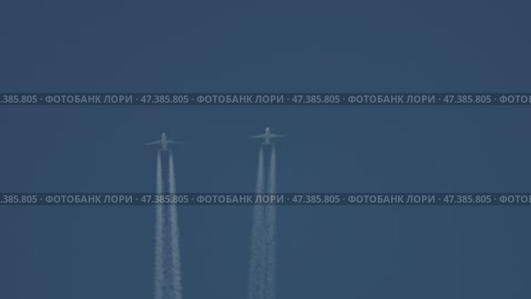 Two airplanes flying together leaving contrails in the blue sky. Стоковое видео, видеограф Константин Шишкин / Фотобанк Лори