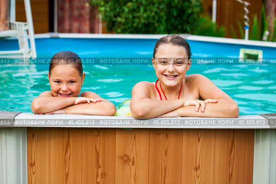 Two beautiful girls sisters pose in a home pool. Стоковое фото, фотограф Андрей Аркуша / Фотобанк Лори