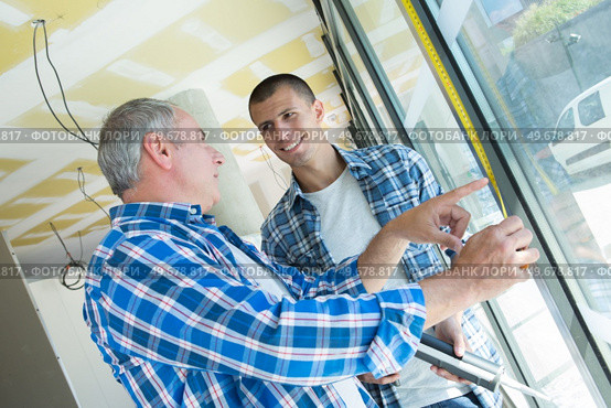 two builders worker installing glass windows. Стоковое фото, агентство Ingram Publishing / Фотобанк Лори