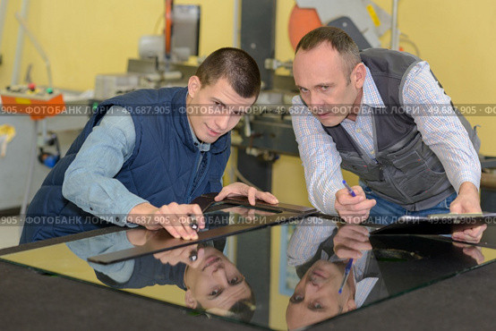 two careful workmen work at pvc windows factory. Стоковое фото, агентство Ingram Publishing / Фотобанк Лори