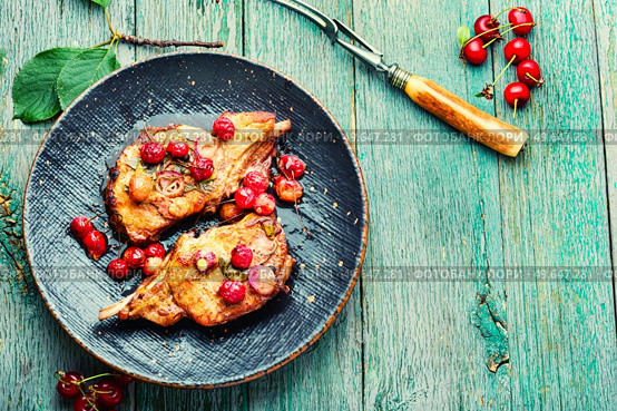 Two cooked steaks in a cherry marinade. Fried meat with berry sauce on old wooden background. Space for text. Meat on the bone roasted in berry sauce. Стоковое фото, агентство Ingram Publishing / Фотобанк Лори