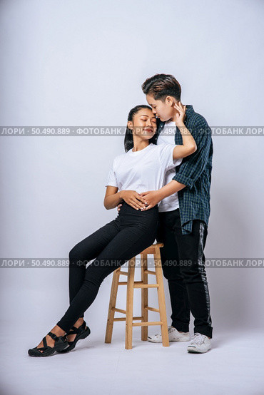 Two female lovers hugged one another and sat in a chair. Стоковое фото, агентство Ingram Publishing / Фотобанк Лори