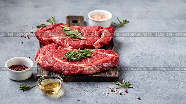 Two Fresh Raw meat Prime Black Angus Beef Steaks, Rib Eye, Denver, on wooden cutting board. Стоковое фото, фотограф Ирина Буракова / Фотобанк Лори