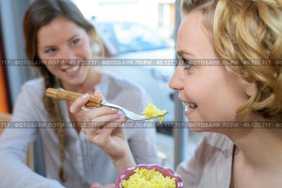 two girls having fun talking and eating in asian restaurant. Стоковое фото, агентство Ingram Publishing / Фотобанк Лори