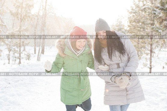 Two girls walk in the forest covered in snow. Стоковое фото, фотограф Kirill Kedrinskiy / Ingram Publishing / Фотобанк Лори