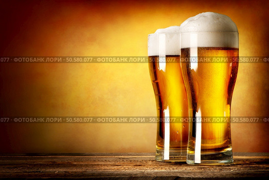 Two glasses of lager on a wooden table. Two glasses of lager. Стоковое фото, агентство Ingram Publishing / Фотобанк Лори