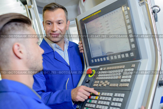 two machine operators working together. Стоковое фото, агентство Ingram Publishing / Фотобанк Лори