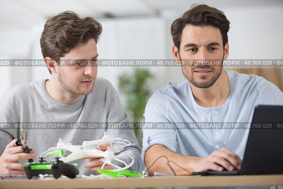 two men are getting online help to assemble a drone. Стоковое фото, агентство Ingram Publishing / Фотобанк Лори
