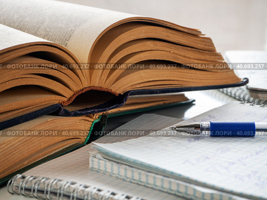 Two old thick books are on the table, one on top of the other. Nearby are notebooks with notes. Books and notebooks are open. The pen is on the notebooks. Background for education and libraries. Стоковое фото, фотограф Бузмакова Светлана / Фотобанк Лори
