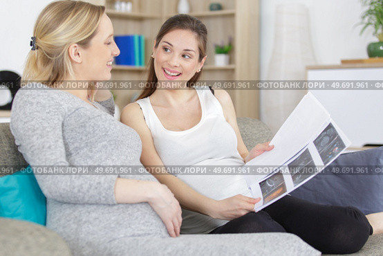 two pregnant young women talking about xrays. Стоковое фото, агентство Ingram Publishing / Фотобанк Лори