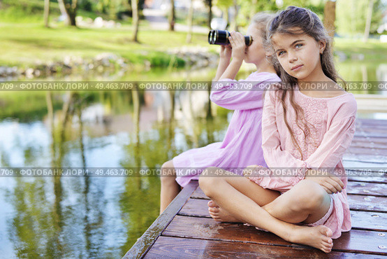 Two relaxed freinds sitting on a wet jetty - summer shot. Стоковое фото, агентство Ingram Publishing / Фотобанк Лори